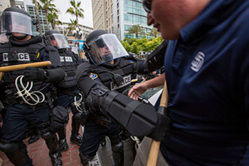 Police officer jabbing a protester