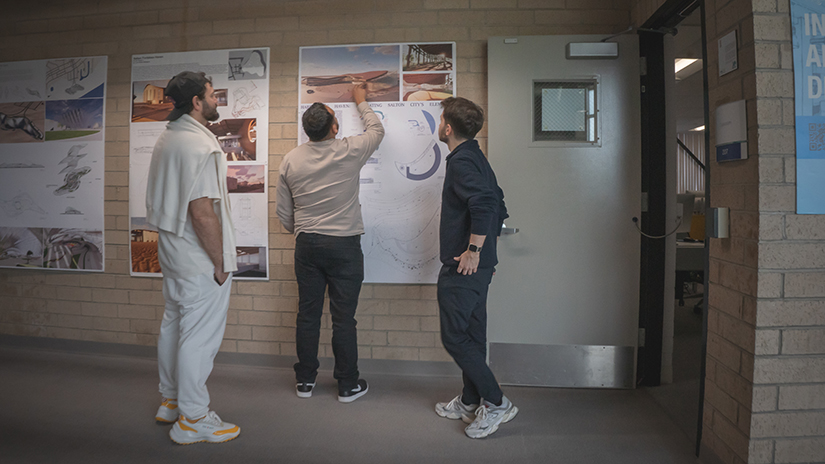 Students viewing final presentation boards from the Architecture Studio 3 class