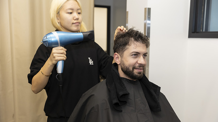 Learning how to blow dry.